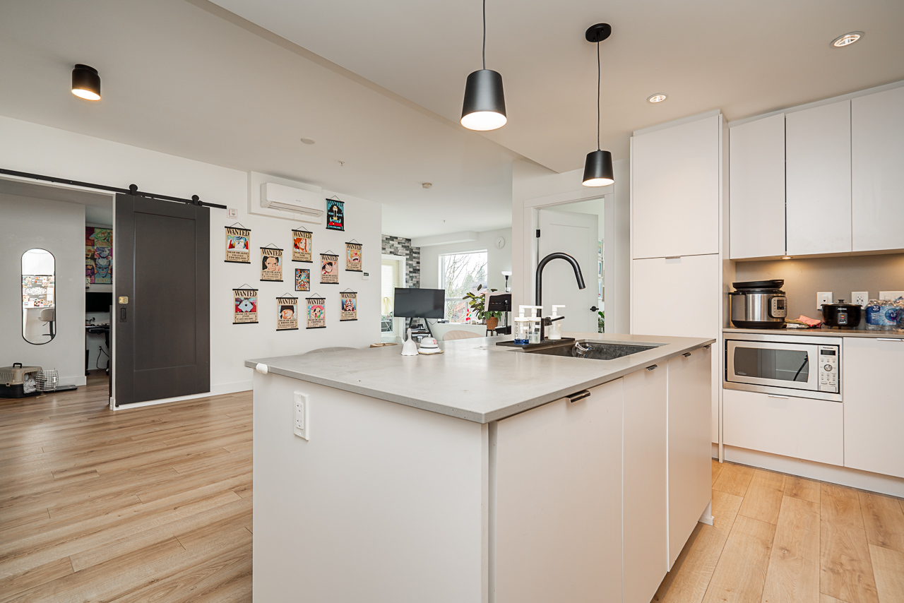 Unit 301 2493 Montrose Avenue Abbotsford-7 – Copy Quartz kitchen with island and stainless steel appliances